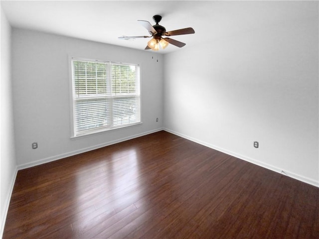 spare room featuring dark wood-type flooring and ceiling fan