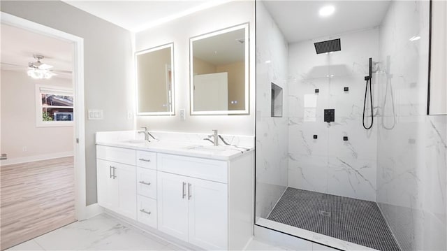 full bathroom featuring a marble finish shower, marble finish floor, double vanity, and a sink