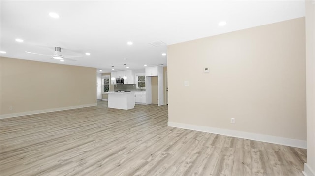 unfurnished living room featuring recessed lighting, light wood-type flooring, baseboards, and ceiling fan