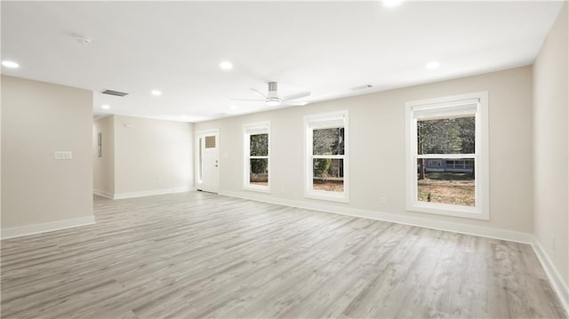 unfurnished living room with plenty of natural light, recessed lighting, light wood-type flooring, and baseboards