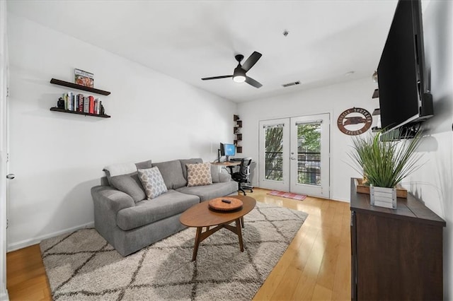 living area with french doors, visible vents, ceiling fan, and wood finished floors