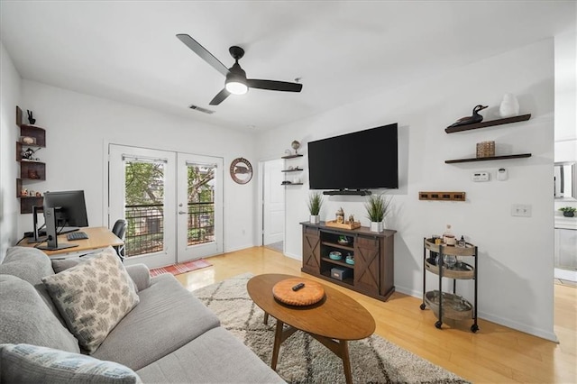 living room featuring french doors, visible vents, light wood-style floors, a ceiling fan, and baseboards