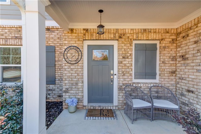 entrance to property with covered porch and brick siding