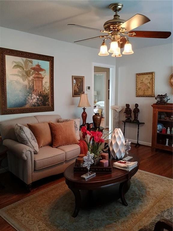 living room with wood finished floors, a ceiling fan, and baseboards