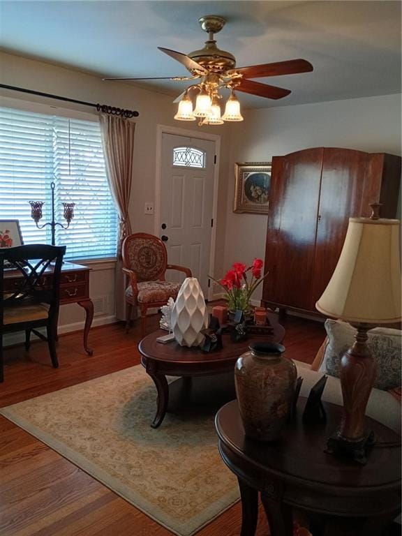 living area with wood finished floors and a ceiling fan