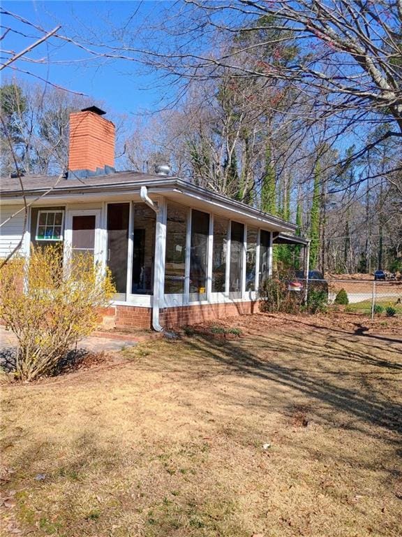 back of property with a sunroom and a chimney