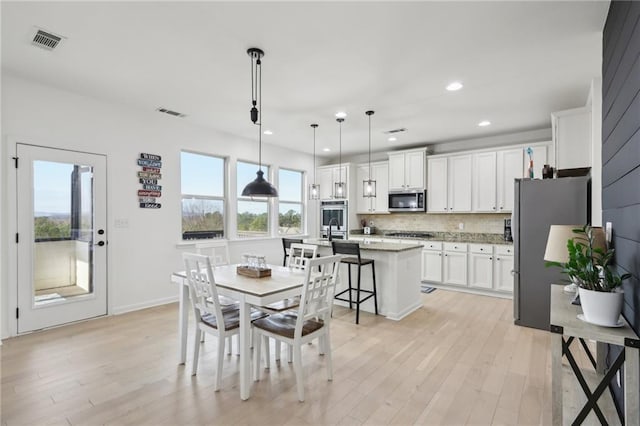 dining room featuring sink and light hardwood / wood-style flooring