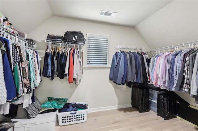 walk in closet featuring vaulted ceiling and light hardwood / wood-style flooring