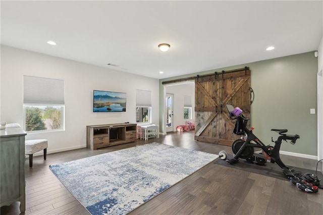 workout area featuring dark hardwood / wood-style floors and a barn door