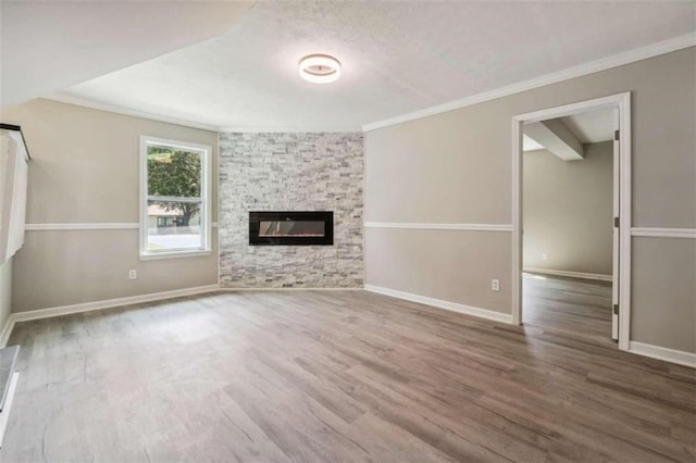 unfurnished living room featuring hardwood / wood-style flooring, a textured ceiling, crown molding, and a stone fireplace