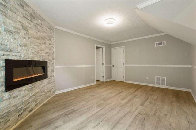 additional living space featuring a fireplace, lofted ceiling, and wood-type flooring