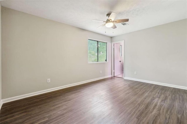 empty room featuring ceiling fan and dark wood-type flooring