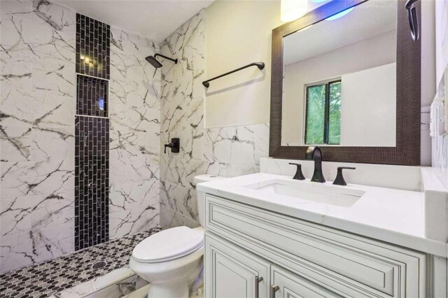 bathroom featuring vanity, tiled shower, and toilet