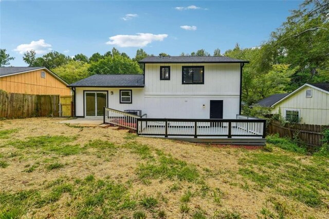 back of property featuring a yard and a wooden deck