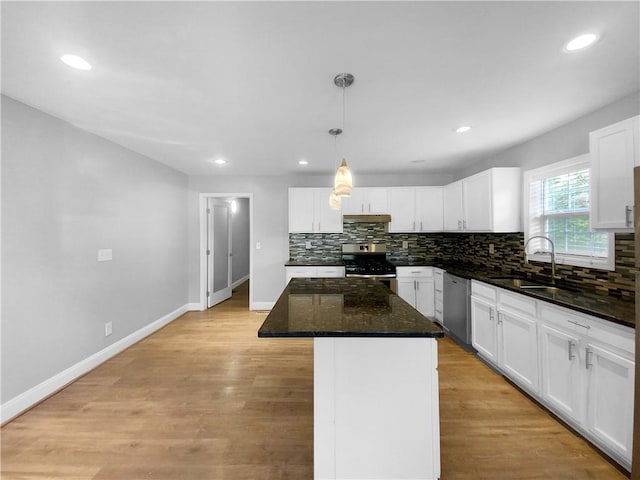 kitchen featuring appliances with stainless steel finishes, a kitchen island, white cabinetry, and sink