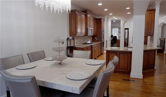 dining space featuring light wood-type flooring and a notable chandelier