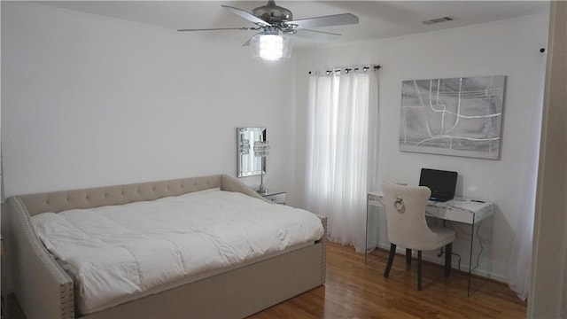 bedroom featuring ceiling fan, wood-type flooring, and multiple windows