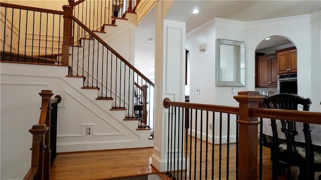 staircase featuring hardwood / wood-style floors and ornamental molding