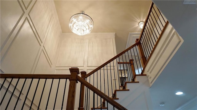 staircase with an inviting chandelier