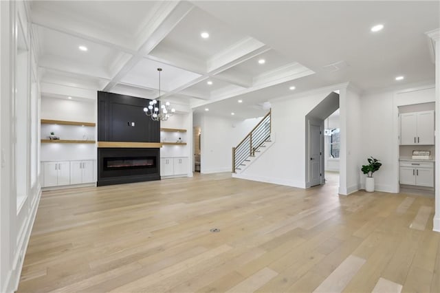 unfurnished living room featuring a fireplace, built in features, light wood-type flooring, beam ceiling, and coffered ceiling