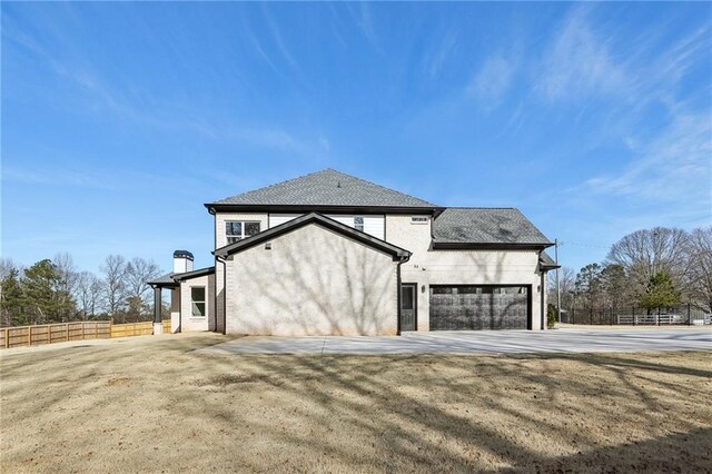 view of side of property featuring a garage and a yard