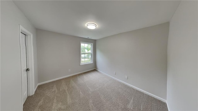 carpeted empty room with baseboards