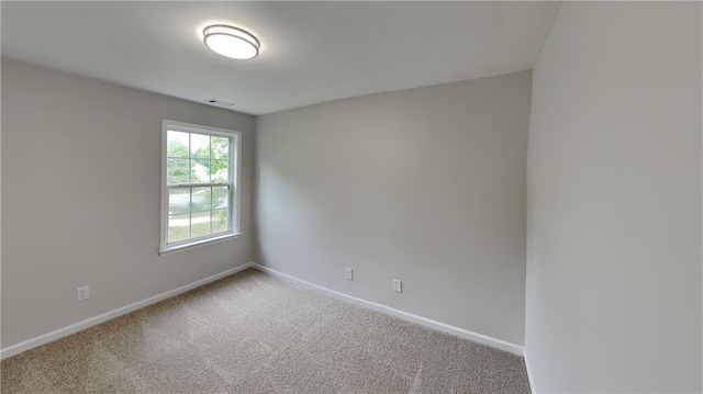 carpeted spare room featuring baseboards