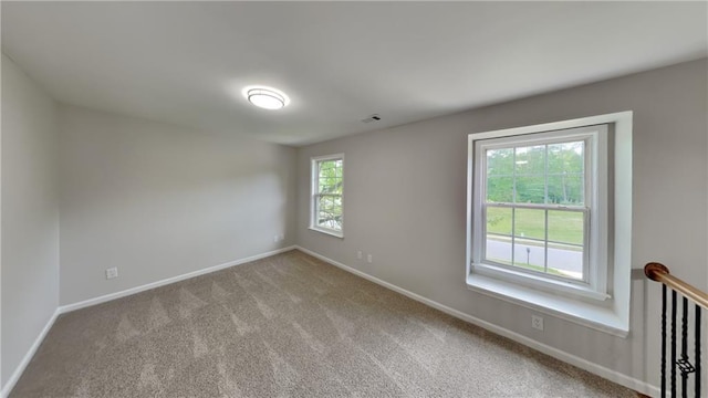 empty room featuring baseboards, visible vents, and carpet flooring