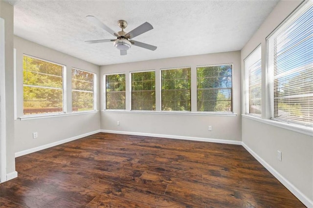 unfurnished sunroom featuring ceiling fan and a wealth of natural light