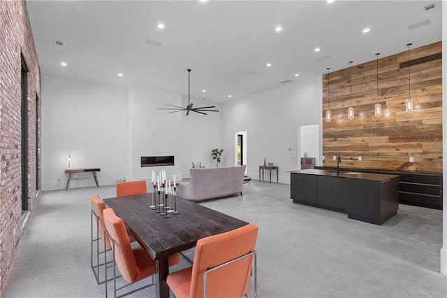538 Main St, Palmetto, GA 30268 - dining room featuring finished concrete flooring, wood walls, recessed lighting, a towering ceiling, and a ceiling fan