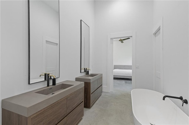 538 Main St, Palmetto, GA 30268 - bathroom with ensuite bath, finished concrete floors, two vanities, a freestanding bath, and a towering ceiling