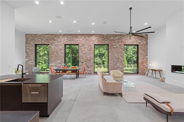 538 Main St, Palmetto, GA 30268 - living area featuring brick wall, finished concrete flooring, recessed lighting, ceiling fan, and healthy amount of natural light