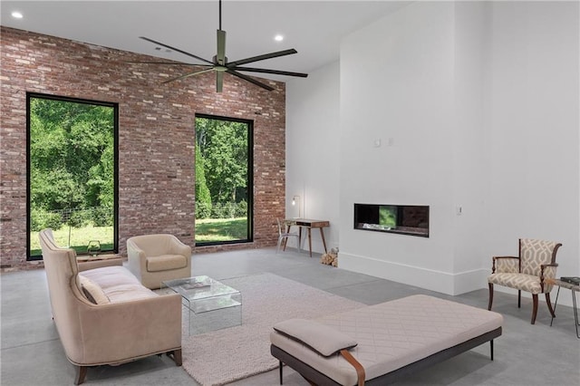 538 Main St, Palmetto, GA 30268 - living area featuring brick wall, ceiling fan, a fireplace, a high ceiling, and finished concrete floors