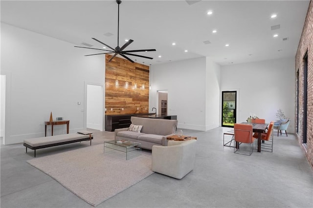 538 Main St, Palmetto, GA 30268 - living room with a towering ceiling, recessed lighting, concrete flooring, wooden walls, and an accent wall