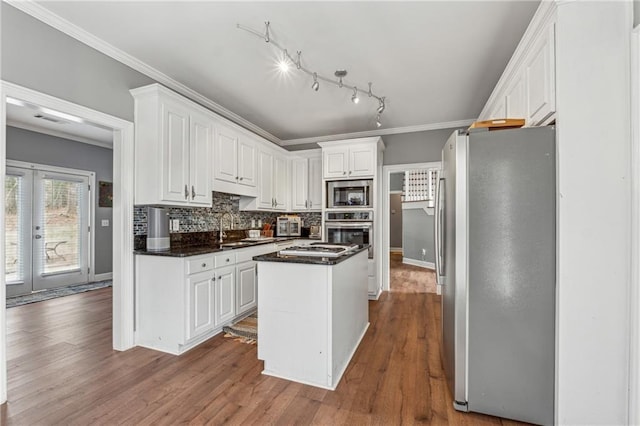 kitchen with stainless steel appliances, a center island, white cabinetry, dark wood-type flooring, and crown molding
