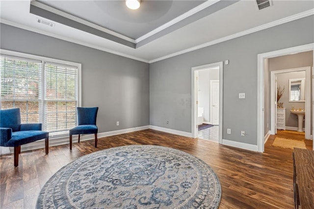 sitting room featuring a tray ceiling, wood finished floors, baseboards, ceiling fan, and ornamental molding