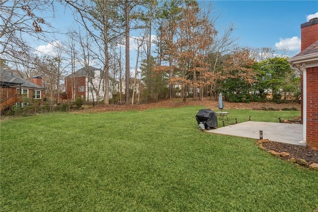view of grassy yard with a patio area