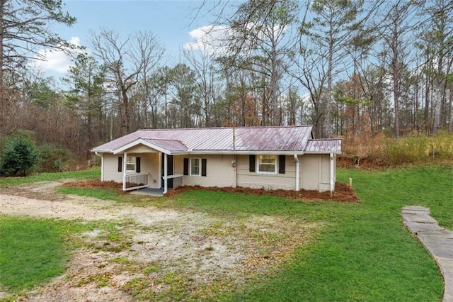 view of front of house featuring a front lawn, a porch, and metal roof