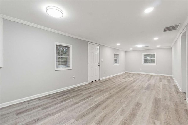 basement with baseboards, visible vents, light wood finished floors, and ornamental molding