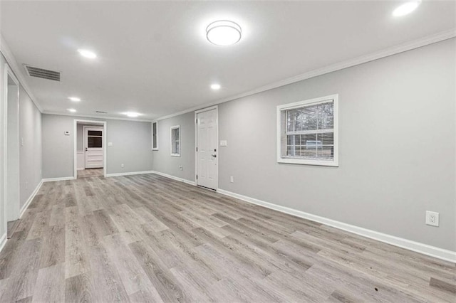 interior space featuring visible vents, baseboards, crown molding, and light wood finished floors