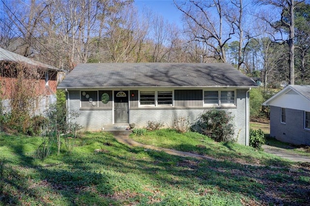 ranch-style house with a front yard and brick siding