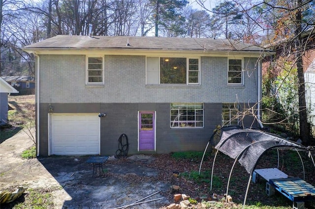 back of property featuring an attached garage and aphalt driveway