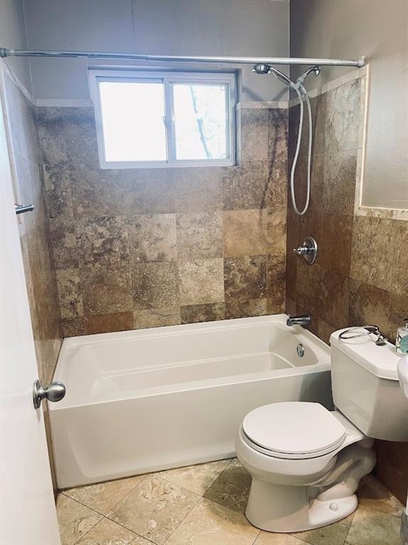 bathroom featuring  shower combination and toilet