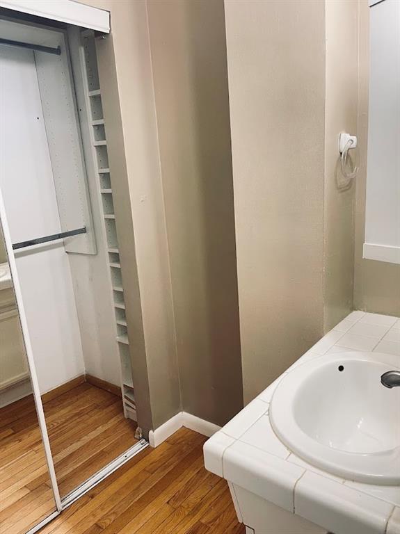 bathroom featuring a sink, baseboards, and wood finished floors