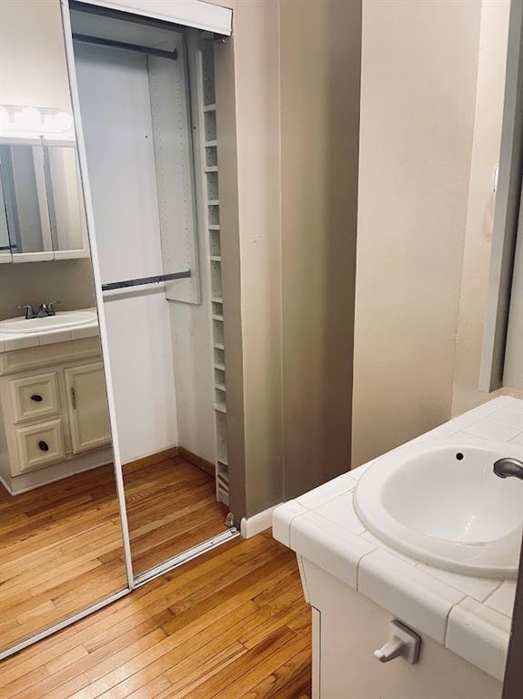 bathroom featuring vanity, hardwood / wood-style flooring, and baseboards