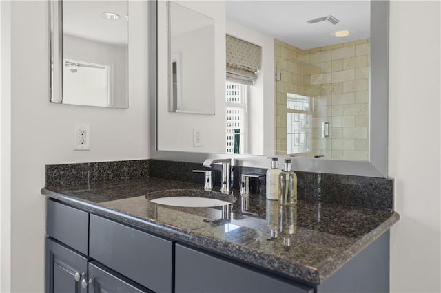 full bathroom with visible vents, a shower stall, and vanity