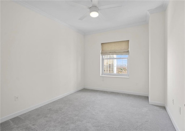 carpeted spare room featuring ceiling fan, baseboards, and ornamental molding