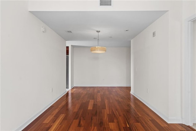 interior space featuring wood finished floors, visible vents, and baseboards