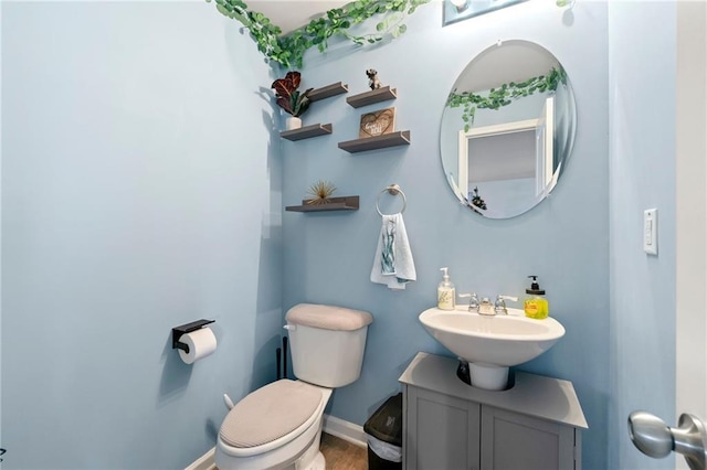 bathroom with hardwood / wood-style flooring, toilet, and sink