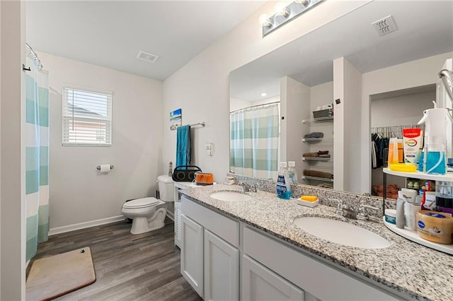 bathroom featuring a shower with shower curtain, wood-type flooring, vanity, and toilet